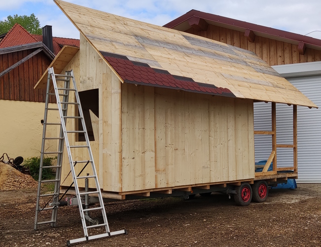 Erste Dachschindeln werden befestigt